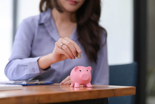Grow Your Trust Bank - Woman Putting Coin into Piggy Bank